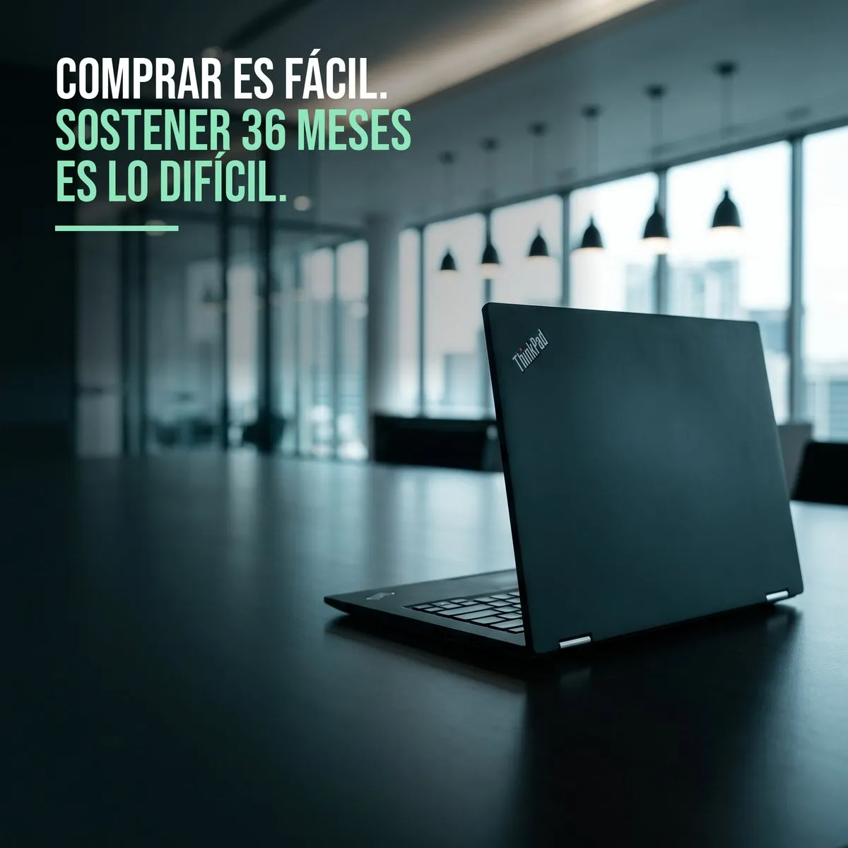 Notebook Lenovo ThinkPad abierta sobre una mesa, en una sala corporativa iluminada con vista a la ciudad